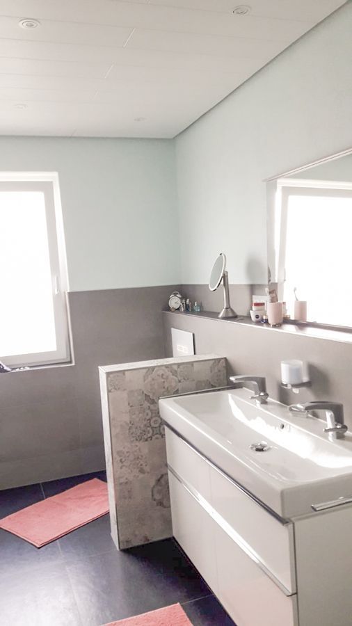 Ein Badezimmer mit Waschbecken, Spiegel und Fenster.