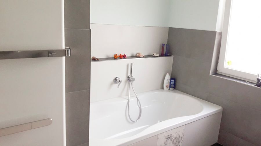 Ein Badezimmer mit Badewanne und Fenster.