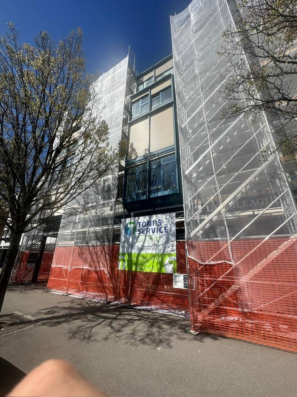 Gerüst mit Sicherheitsgeländer, das am Dach eines Gebäudes befestigt ist, für Bauarbeiten.