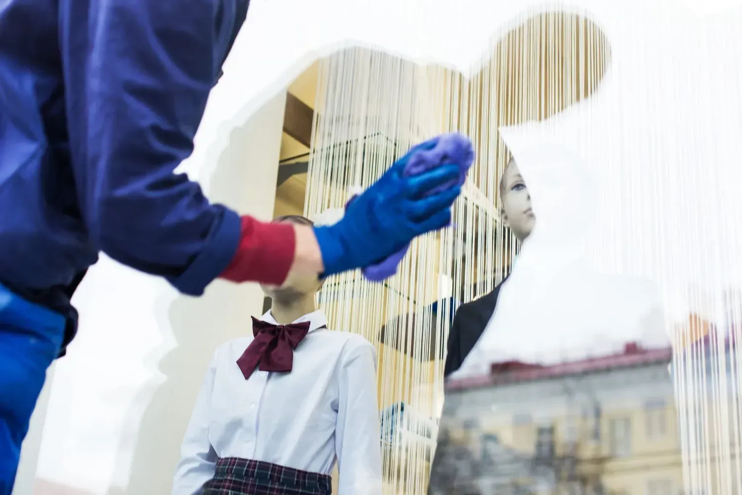 Dos escaladores industriales, vestidos con ropa de trabajo azul, cuelgan de cuerdas mientras limpian.