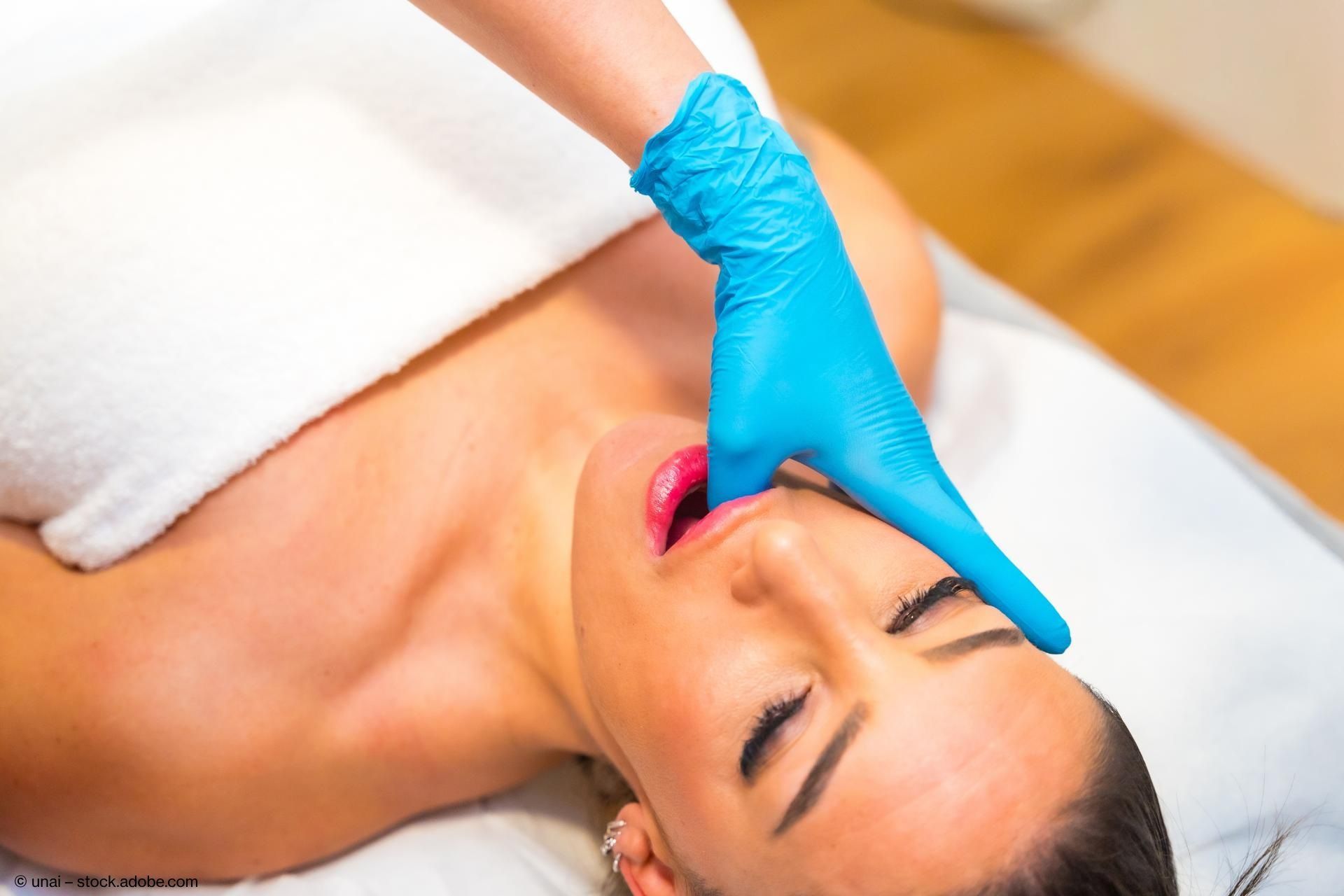 Frau erhält zahnärztliche Behandlung mit Handschuhen.