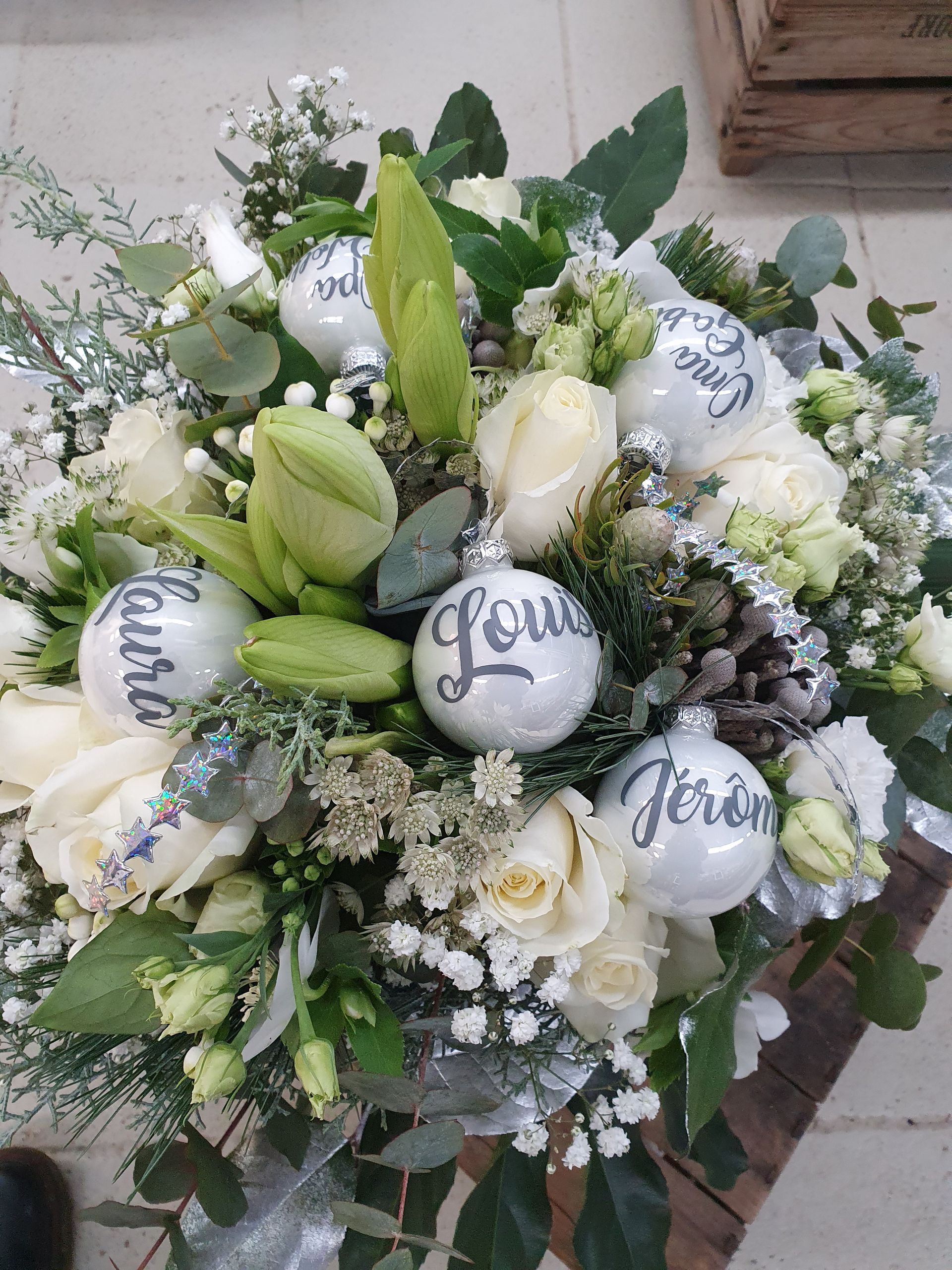 Ein Strauß weißer Blumen und Weihnachtsschmuck auf einem Tisch.