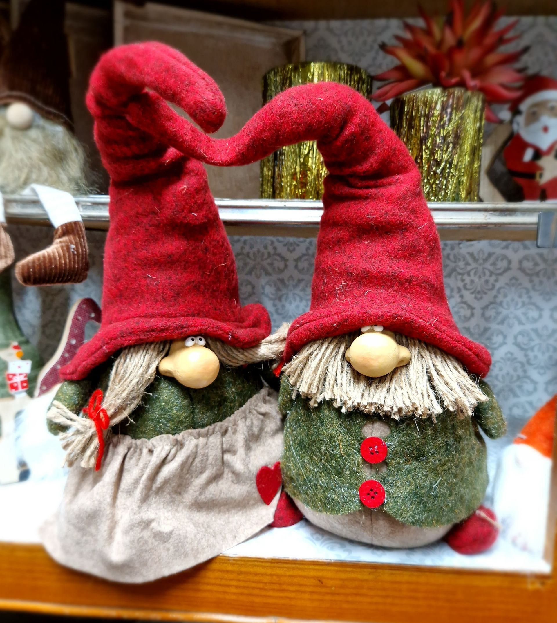 Zwei ausgestopfte Zwerge mit roten Hüten sitzen auf einem Tisch