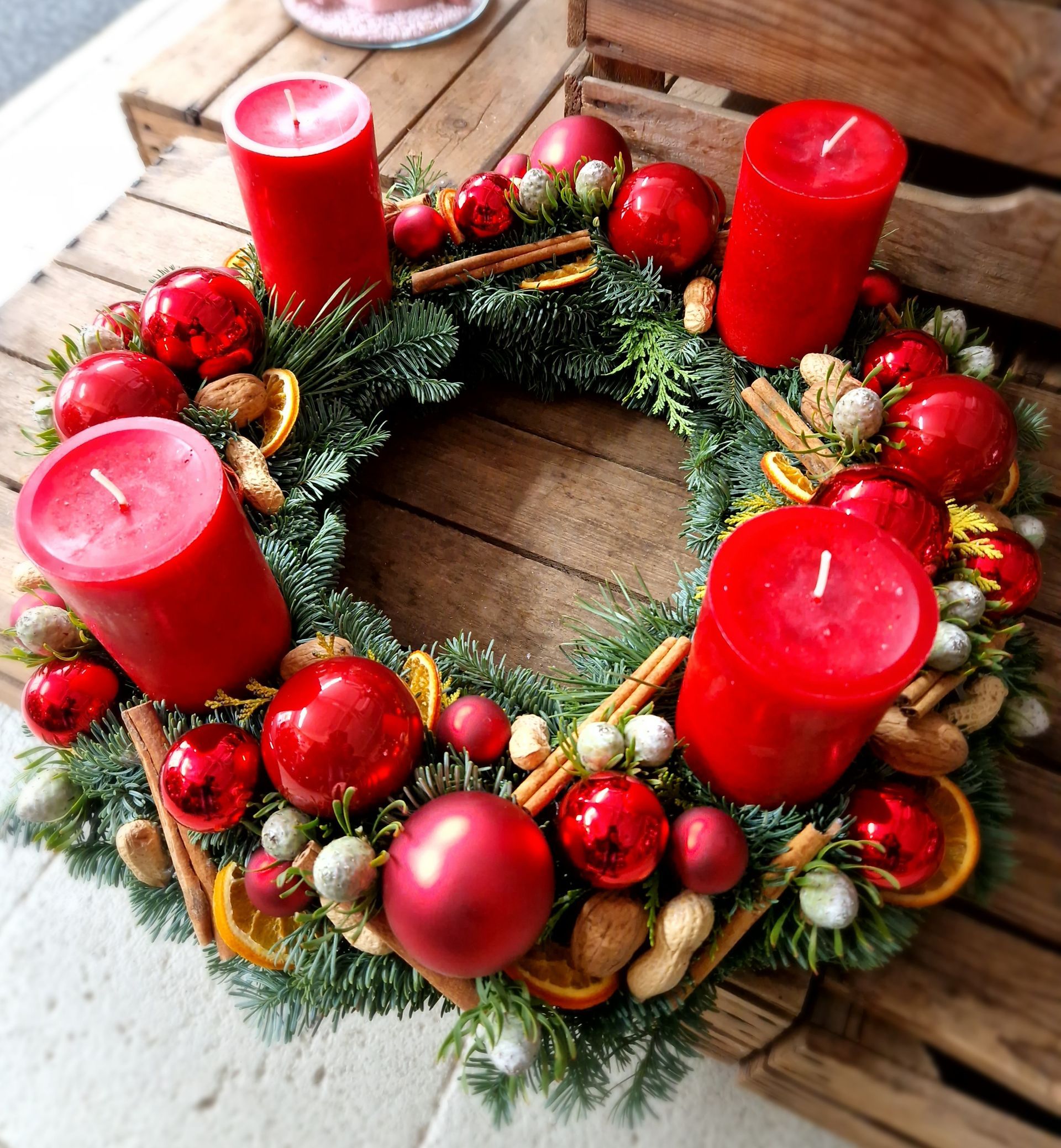 Ein Weihnachtskranz mit roten Kerzen und Dekorationen