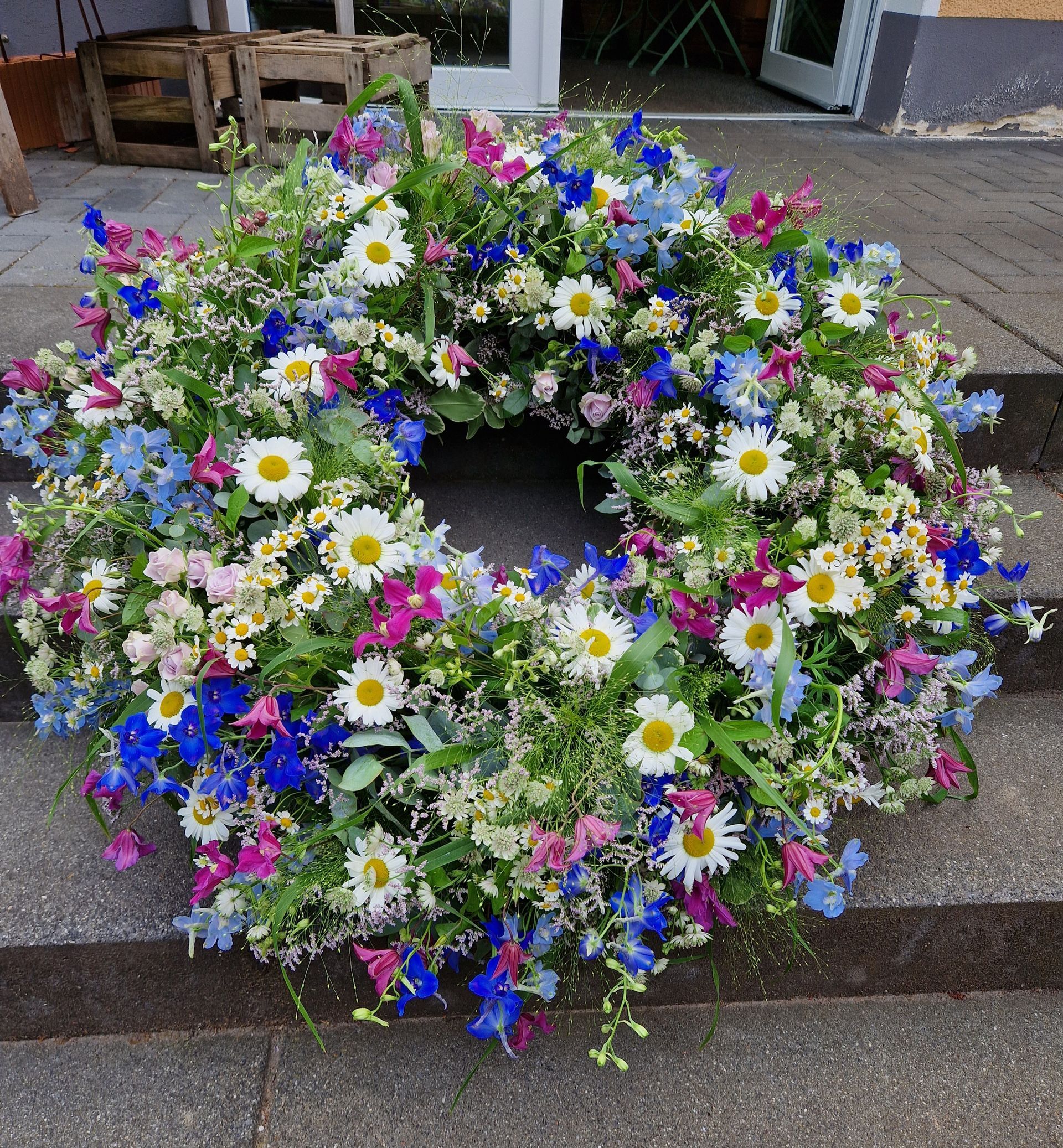 Auf einer Treppe liegt ein Blumenkranz.