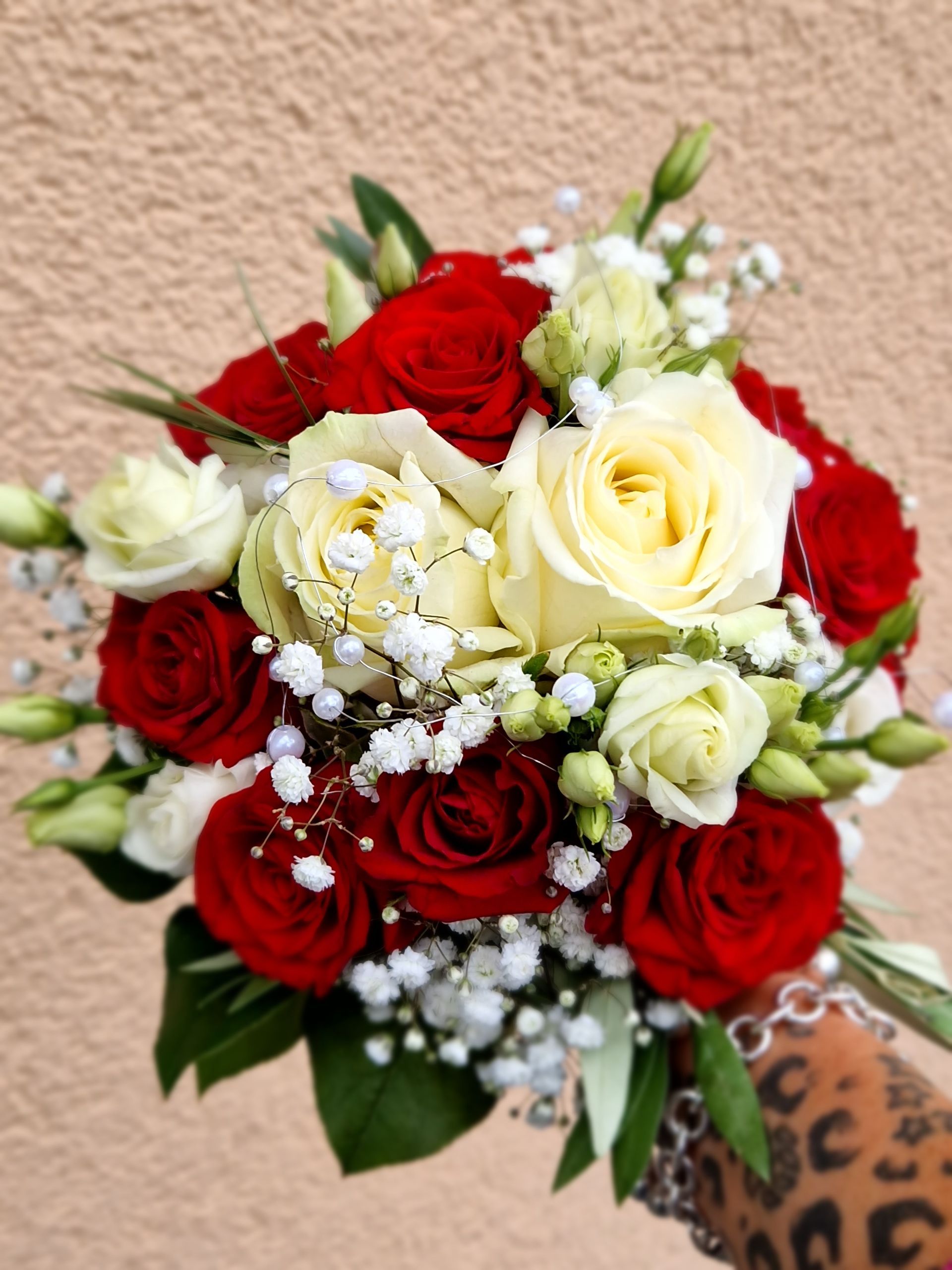 Ein Strauß roter und weißer Rosen mit Schleierkraut