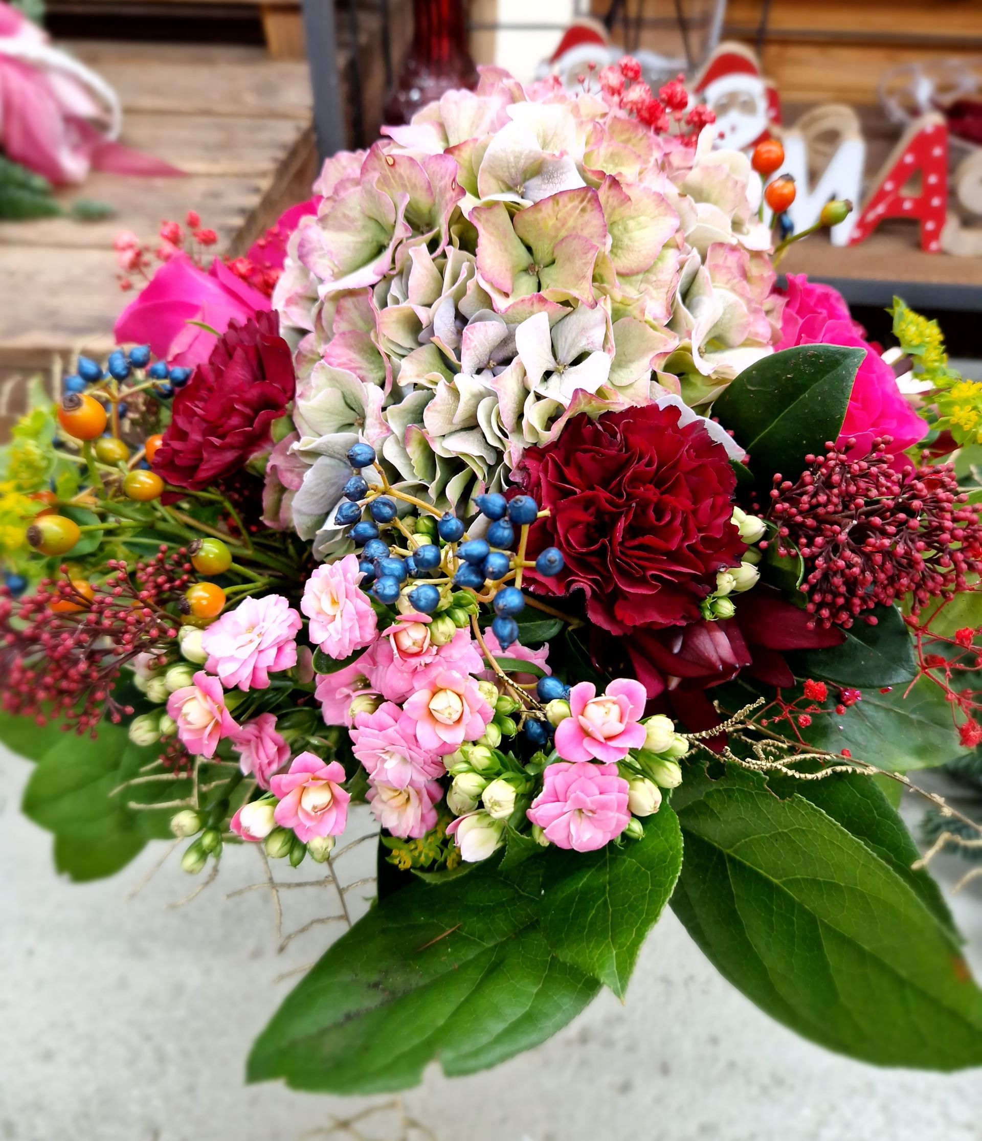 Ein Strauß rosa und roter Blumen mit grünen Blättern