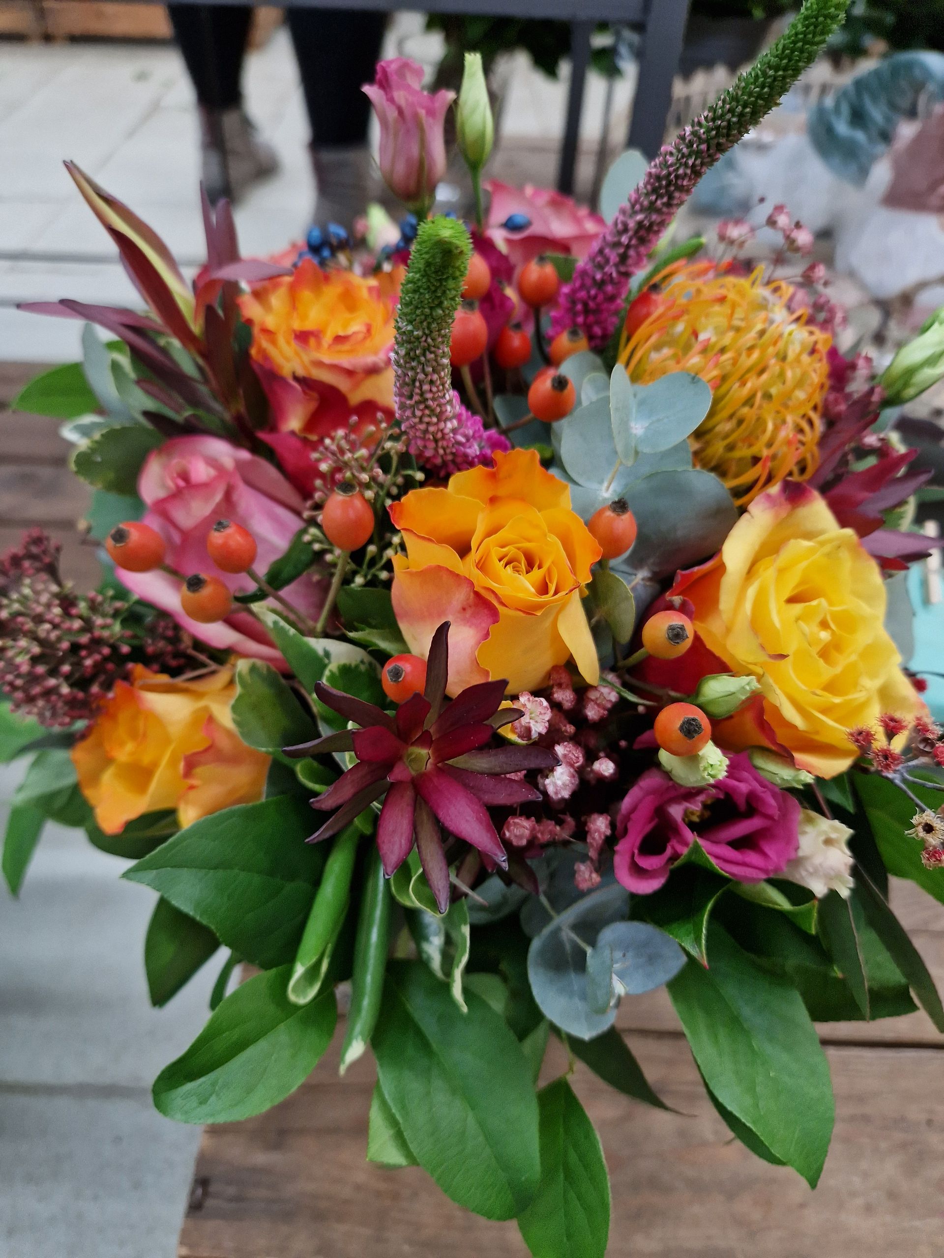 Ein Blumenstrauß steht auf einem Holztisch.