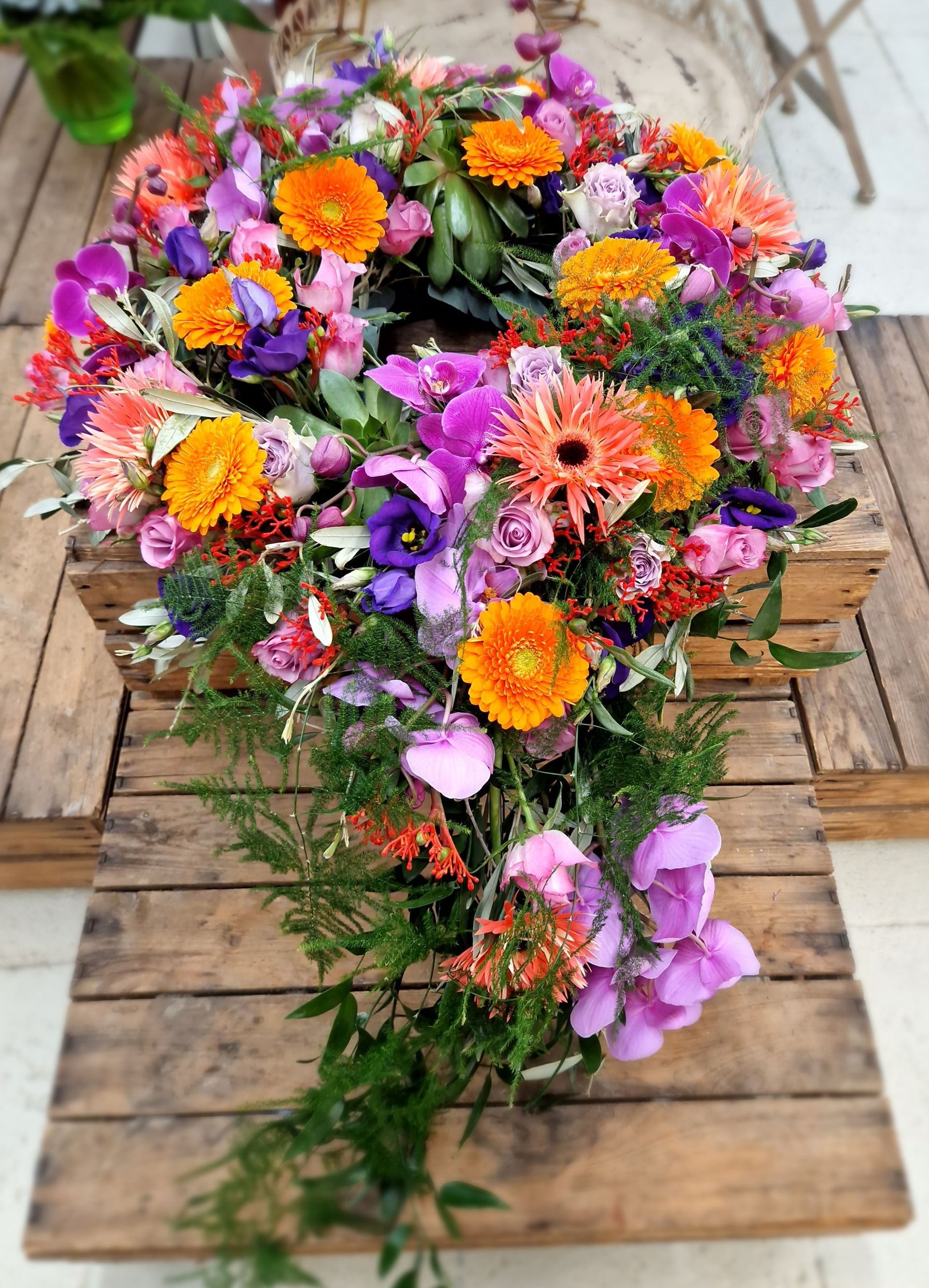 Ein Holztisch mit einem Strauß bunter Blumen darauf.