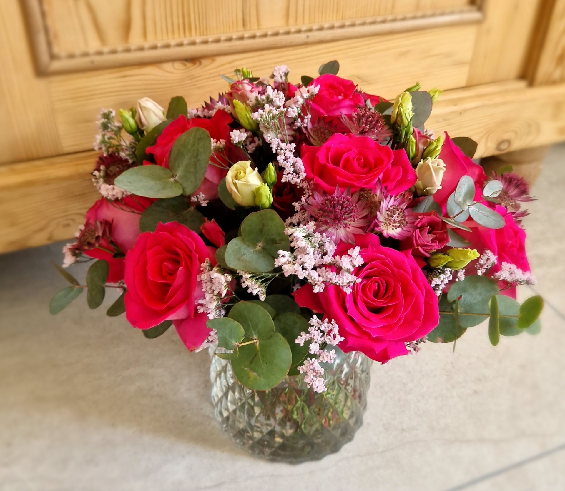 Eine Vase mit rosa Rosen und anderen Blumen gefüllt