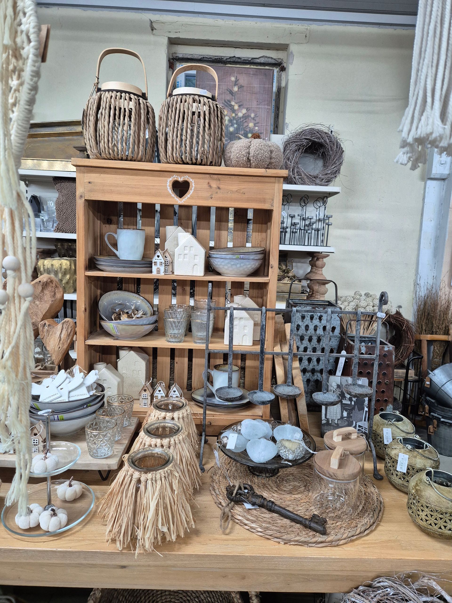Ein Holzregal voller Weidenkörbe und Utensilien in einem Geschäft.