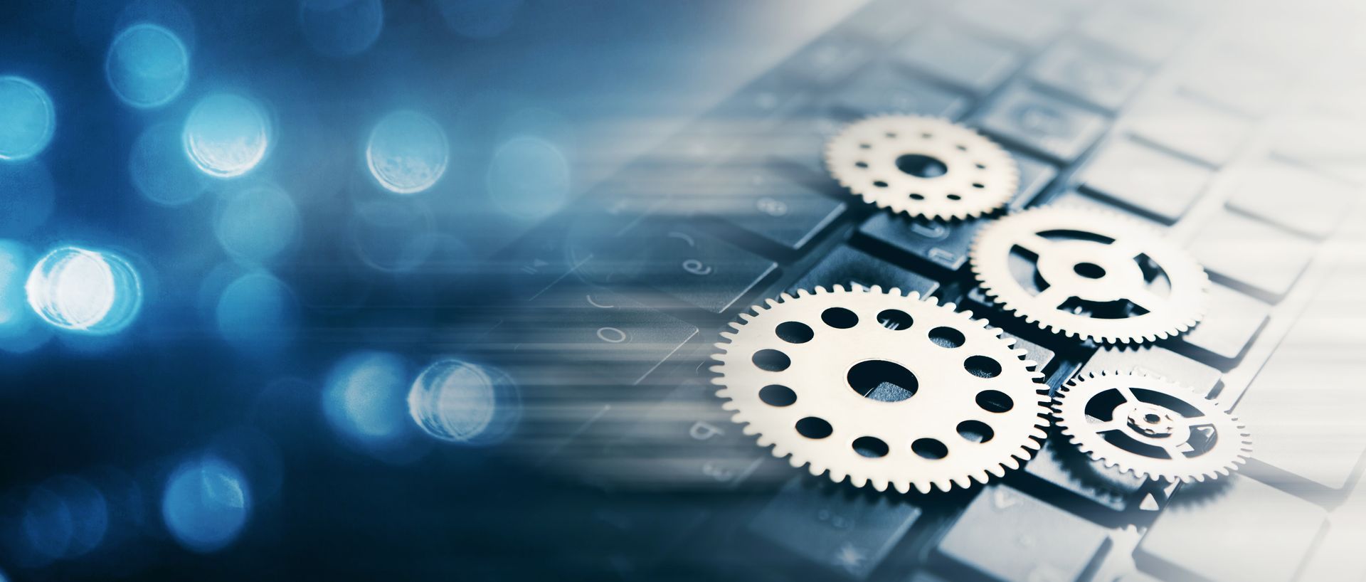 Des engrenages métalliques sur un fond numérique bleu, évoquant la technologie, l'automatisation ou l'ingénierie.