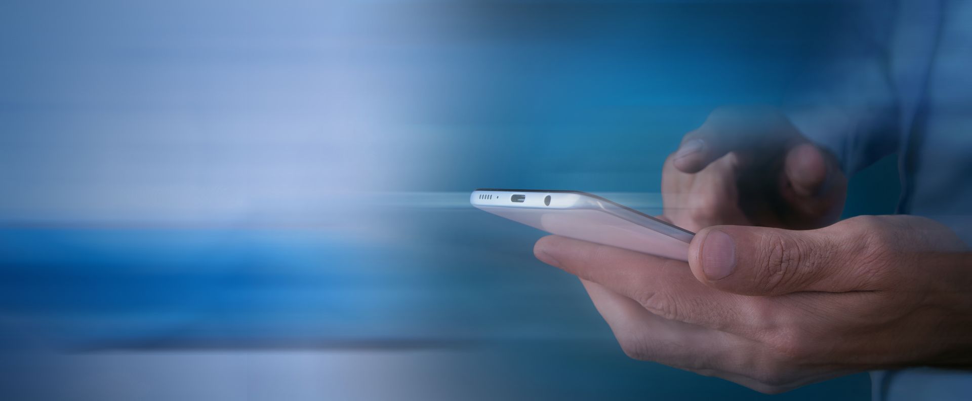 Mains tenant un smartphone sur fond bleu flou