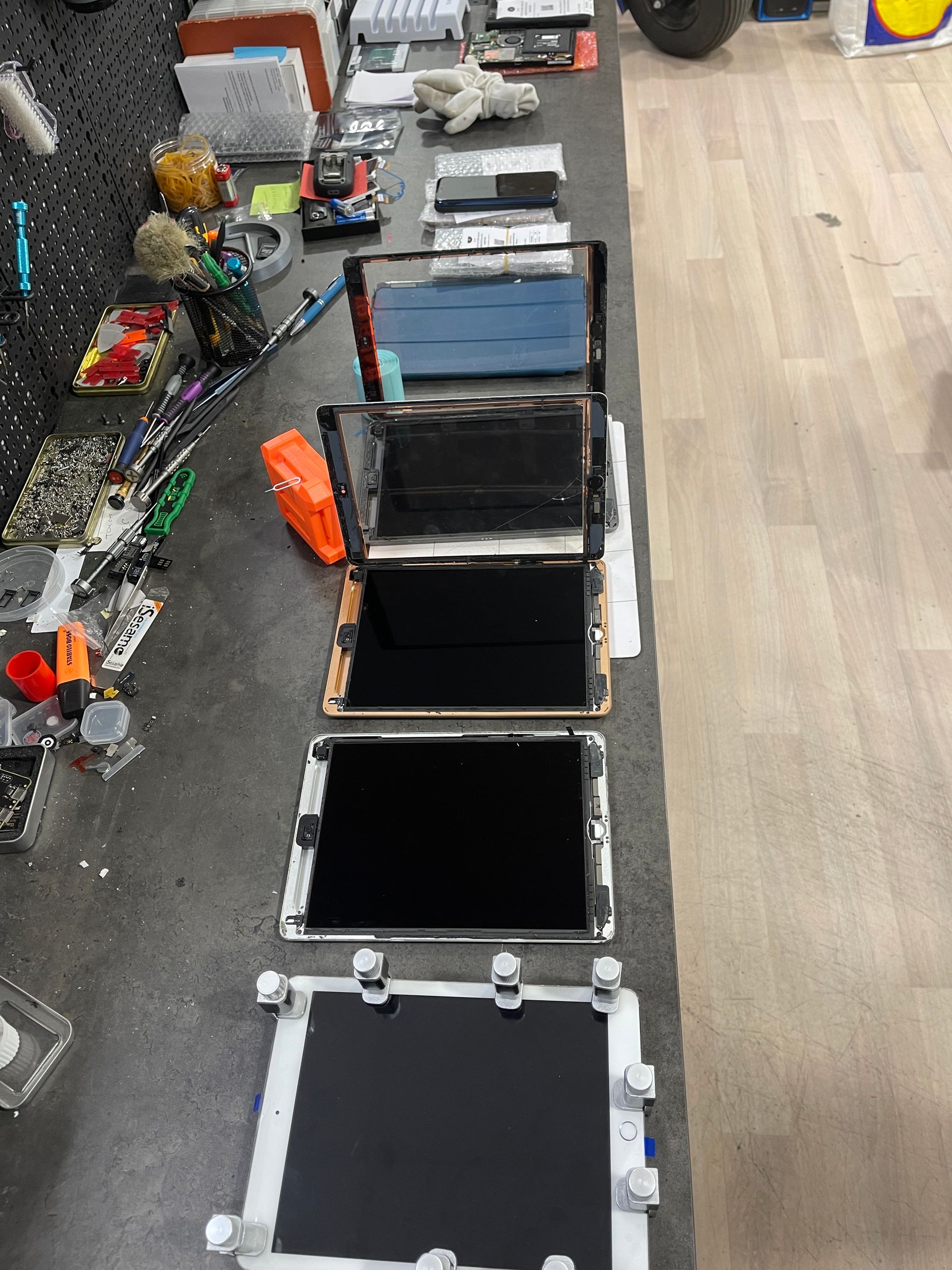 Table d'atelier de réparation avec des écrans de tablettes