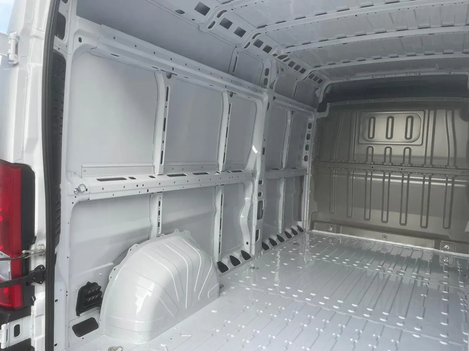 Interior de furgoneta de carga blanca vacía con estructura y paneles de metal.