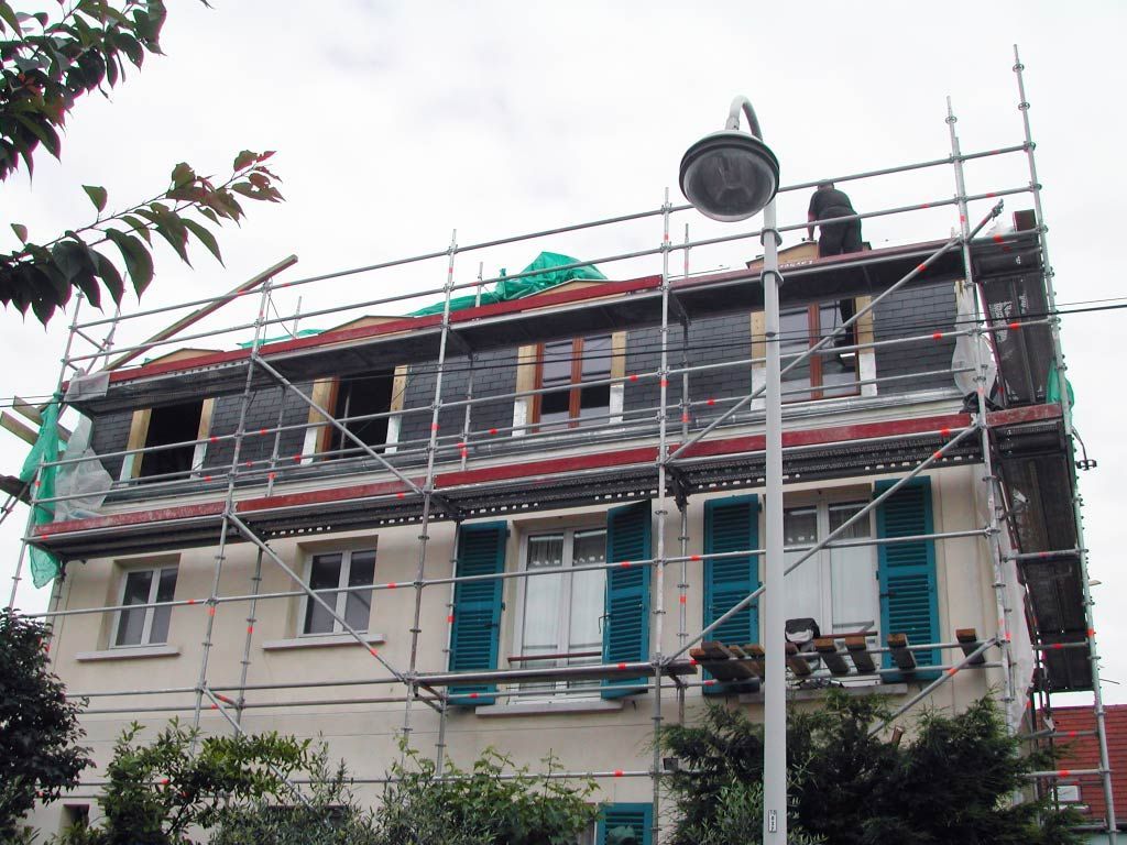 Maison en rénovation avec échafaudages et travaux de toiture