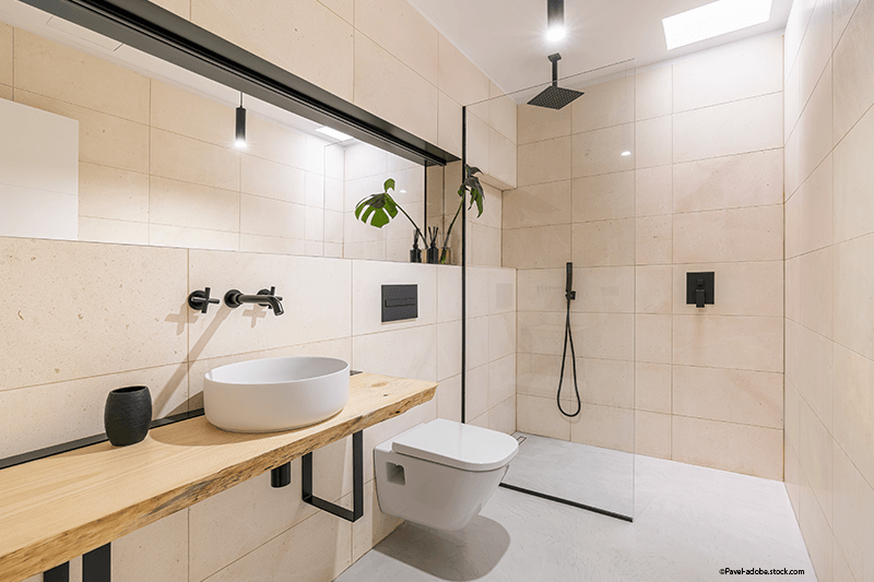 Modernes Badezimmer mit Waschtisch aus Holz, weißem Waschbecken und schwarzen Armaturen.