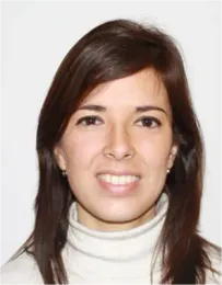Una mujer que lleva un jersey de cuello alto blanco sonríe a la cámara.