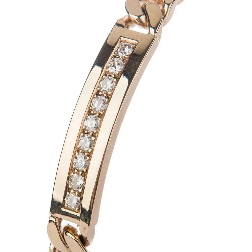 Pulsera de oro con una hilera de piedras transparentes en el centro.