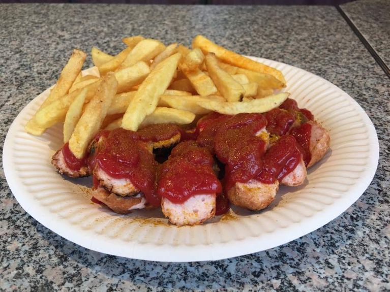 Ein Pappteller mit Fleischbällchen und Pommes Frites auf einem Tisch vom Hähnchen Grill Station Partyservice Ludwigsburg