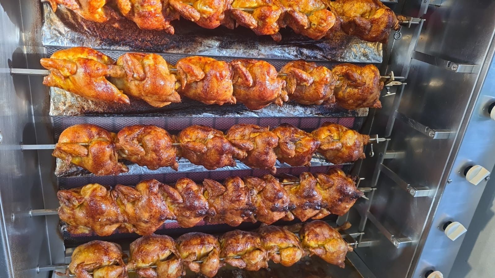 Ein Haufen Hühner backt auf einem Grill vom Hähnchen Grill Station Partyservice Ludwigsburg