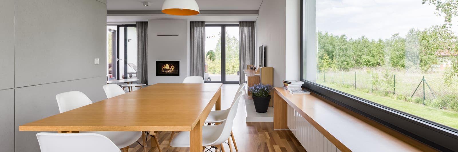 Jolie baie vitrée dans une pièce très lumineuse avec une table et des chaises