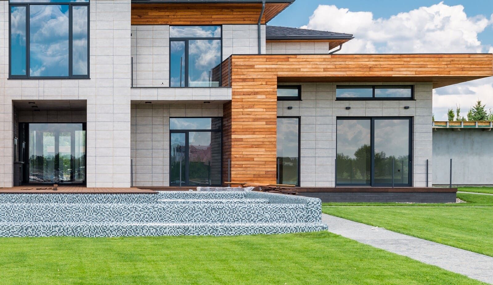 Grande maison moderne avec de nombreuses ouvertures et portes vitrées