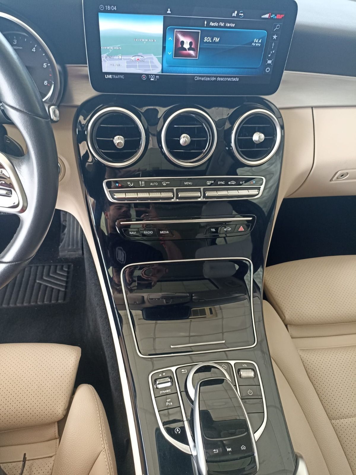Consola central de lujo para automóvil con pantalla de infoentretenimiento, salidas de aire circulares, molduras de madera 