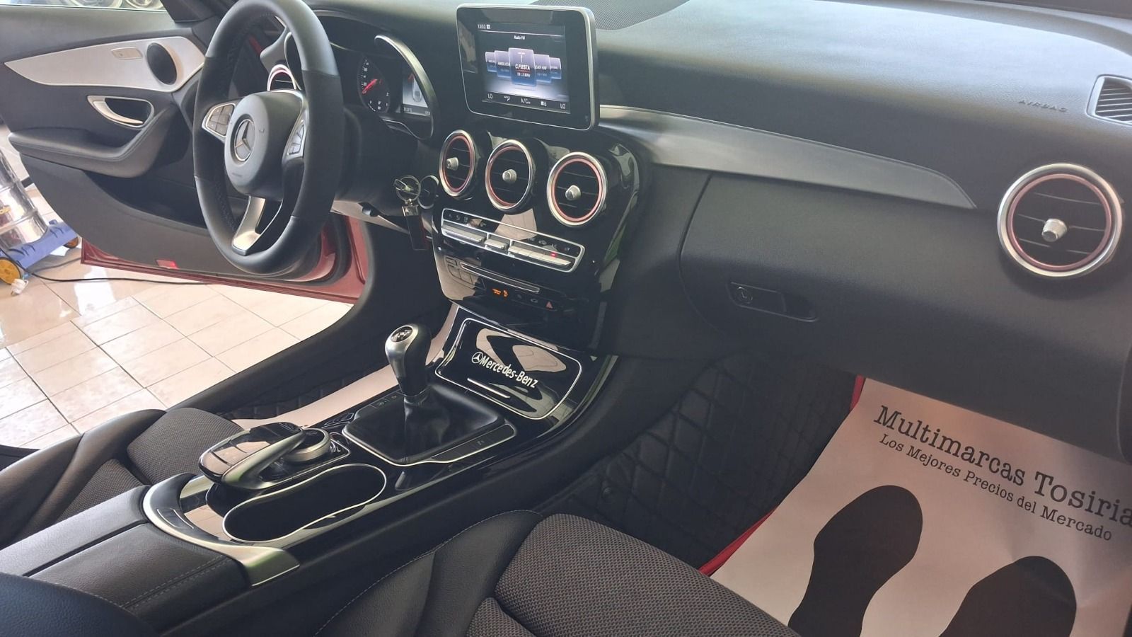 Interior del coche con salpicadero, consola central, volante y pantalla táctil de color negro.