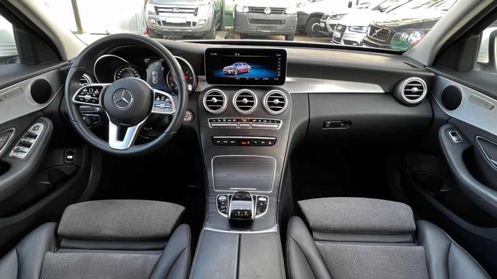 Interior del coche con salpicadero, consola central, volante y asientos delanteros tapizados en gris.