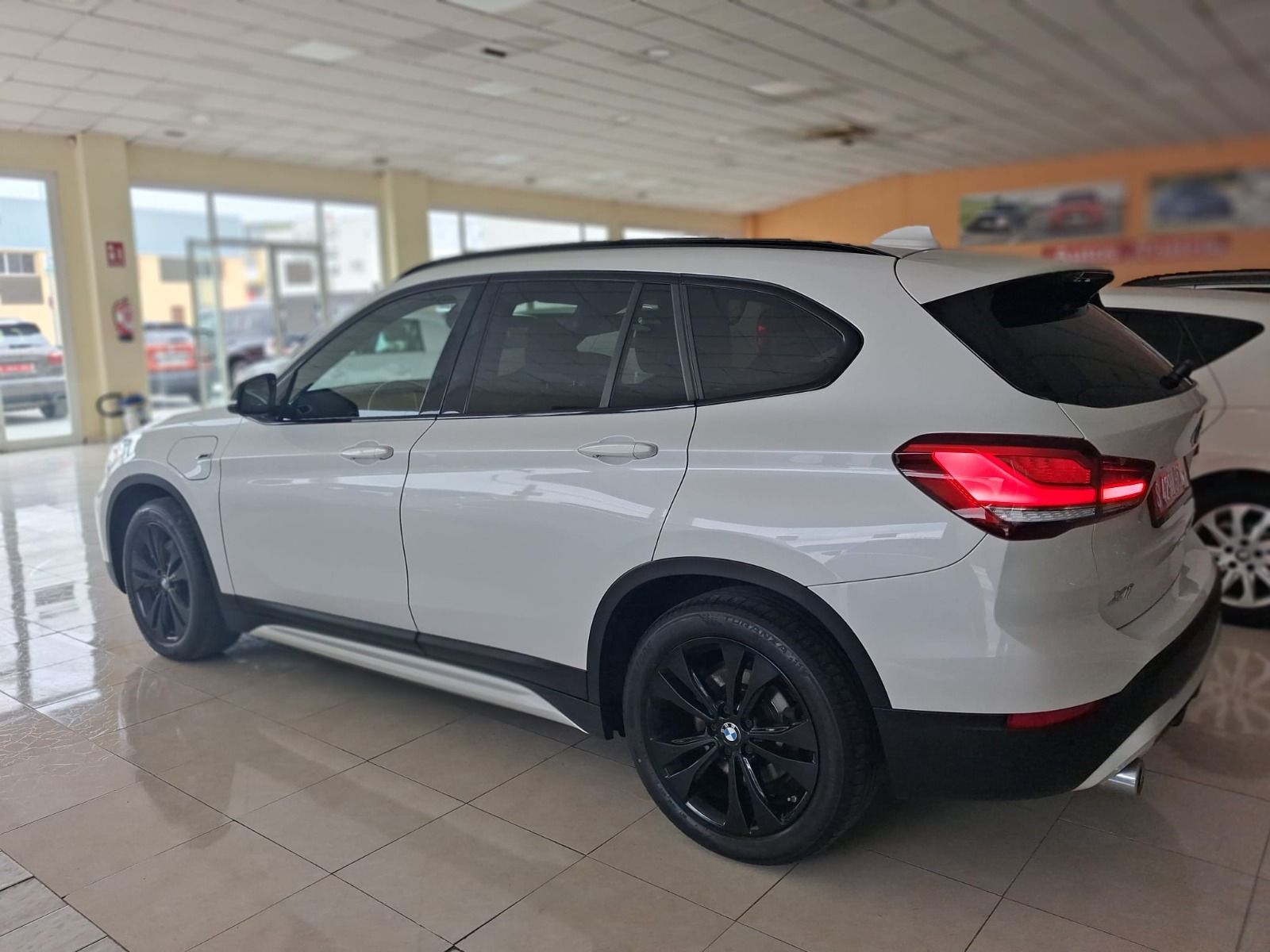 SUV blanco con llantas negras estacionado en el interior de una sala de exposición.