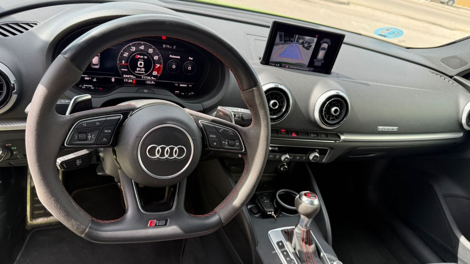 Interior de un Audi con volante, tablero digital y pantalla central.