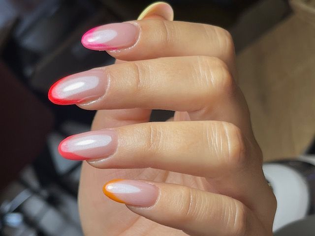 Un primer plano de las uñas de una mujer con diferentes colores.