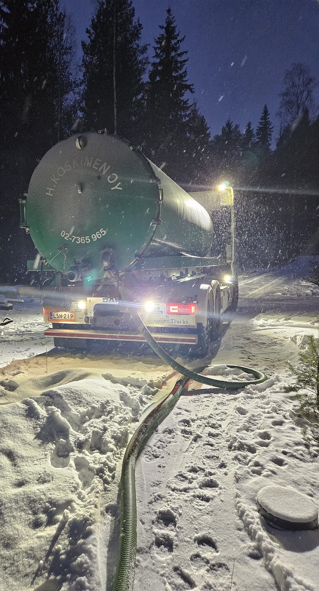 Luminen maisema, jossa ajoneuvo kuljettaa yöllä suurta, vihreää pyöreää esinettä, mahdollisesti satelliittiantennia.