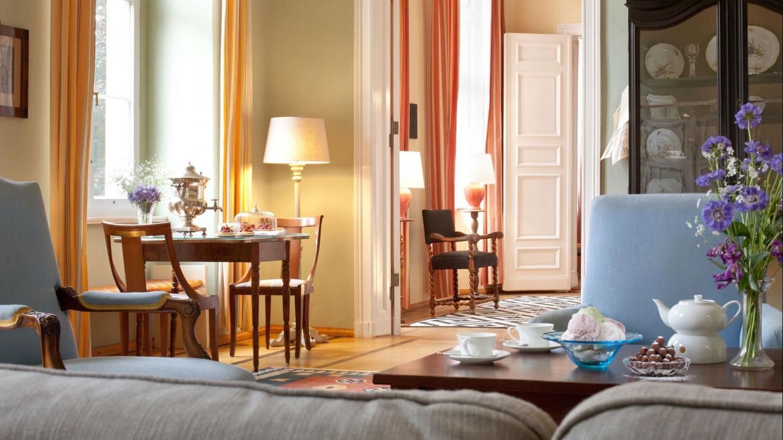 Elegantes Interieur mit Esstisch, Stühlen und Sofa. Natürliches Licht strömt herein.