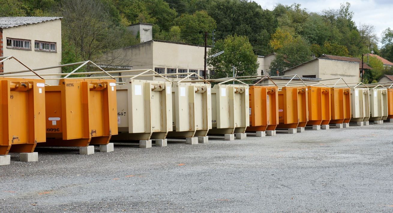Une rangée de bennes à ordures orange et beiges.