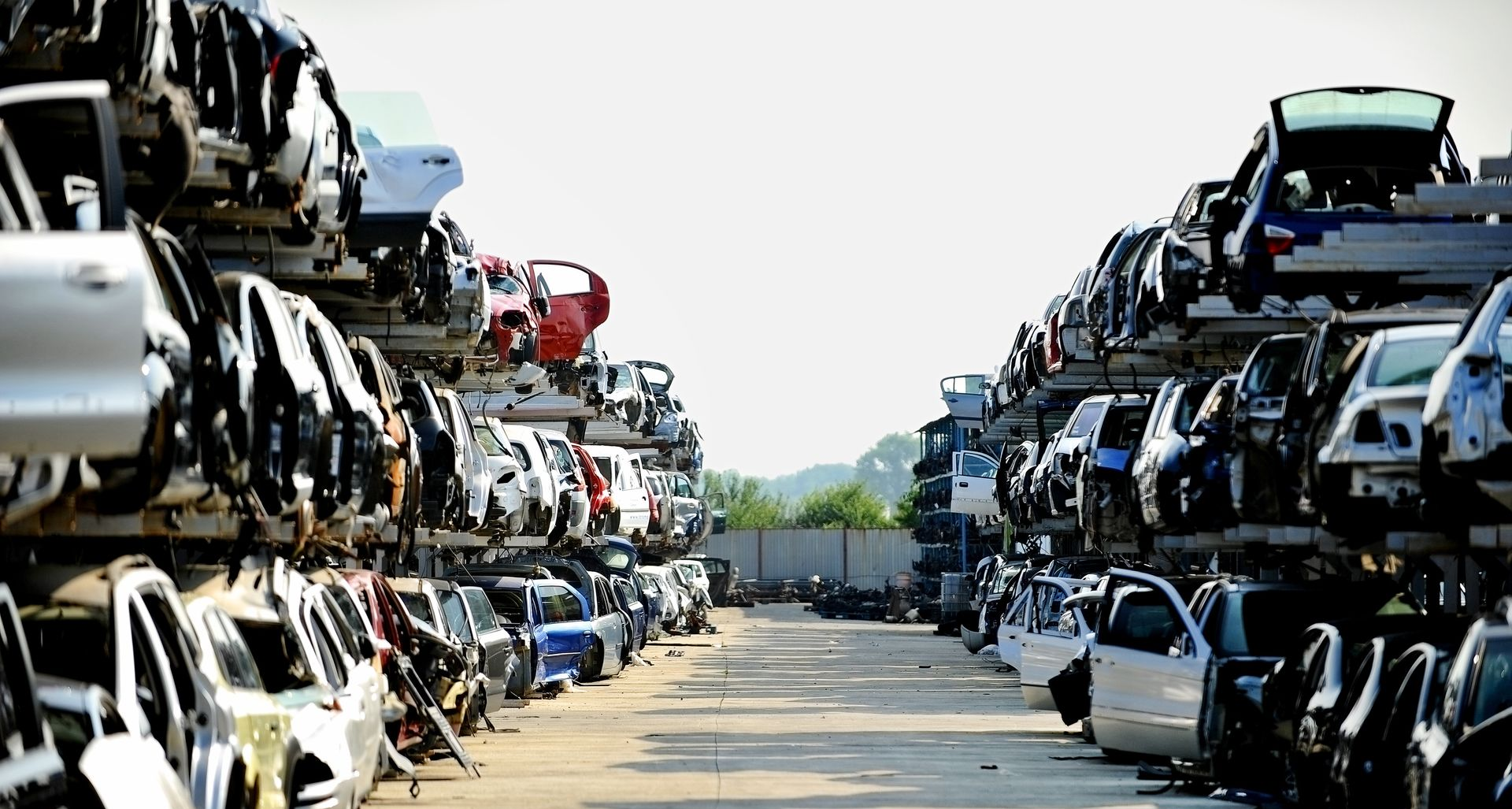 Des rangées de voitures empilées dans une casse.