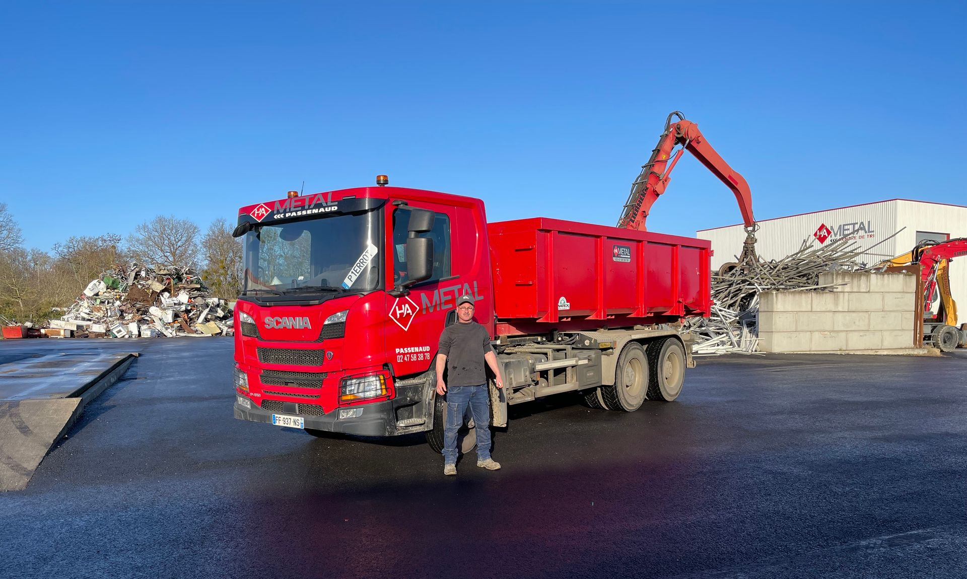Un homme devant un camion rouge.