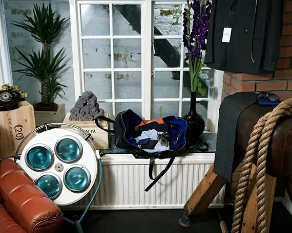A room with a couch and a bag on the window sill