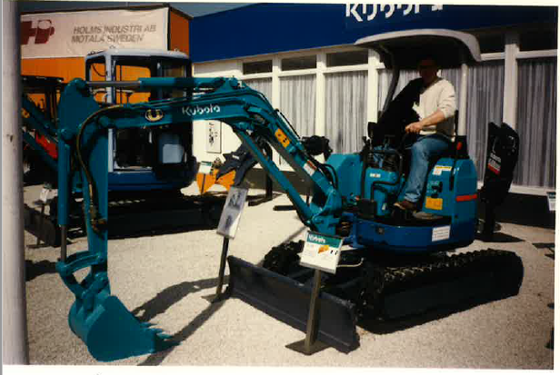 Mini-pelle bleu avec une personne dessus