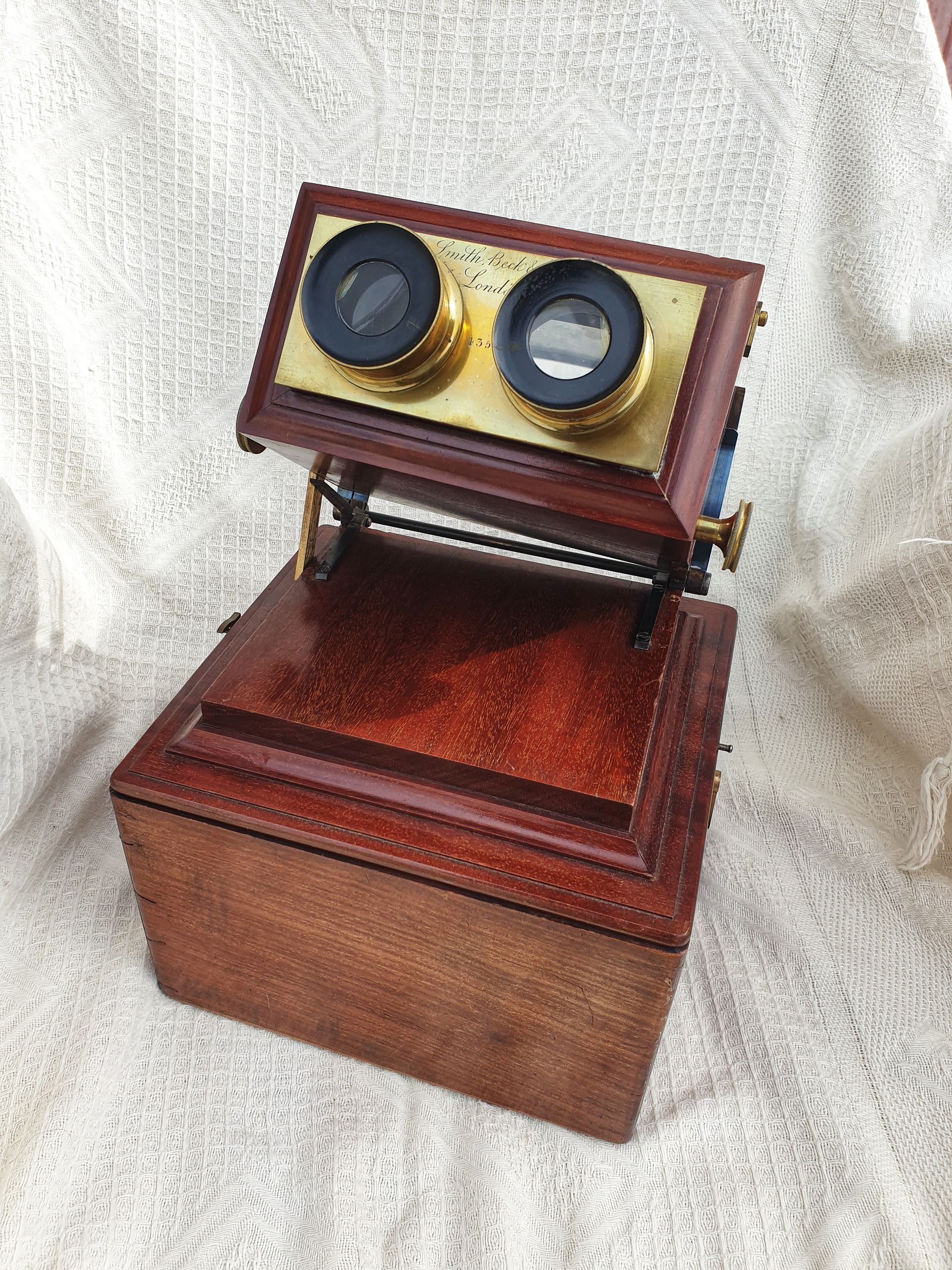 Ancien appareil photo composé de bois avec plaque doré autour des deux lunettes de l'appareil