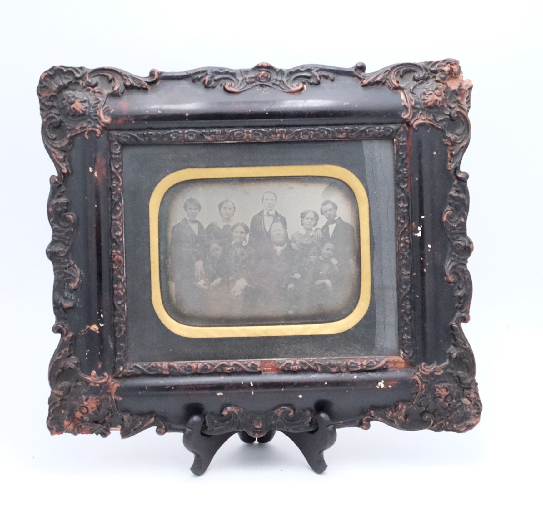 Photo en noir et blanc dans un cadre en bois usé de ce qui semble être une famille du 19ème siècle