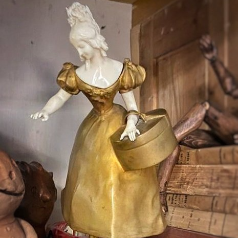 Objet de décoration présentant une statuette de femme en blanc avec une robe dorée de style 18ème siècle