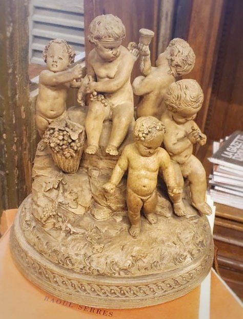 Petite statue de décoration présentant cinq enfant masculin semblant manger du raisin
