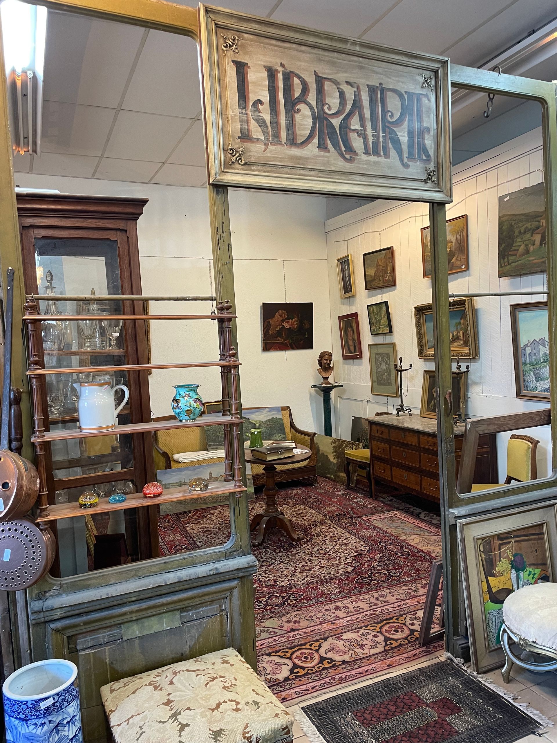 Vue globale de l'espace Librairie d'un antiquaire composé de meubles assortis et de tableaux au mur