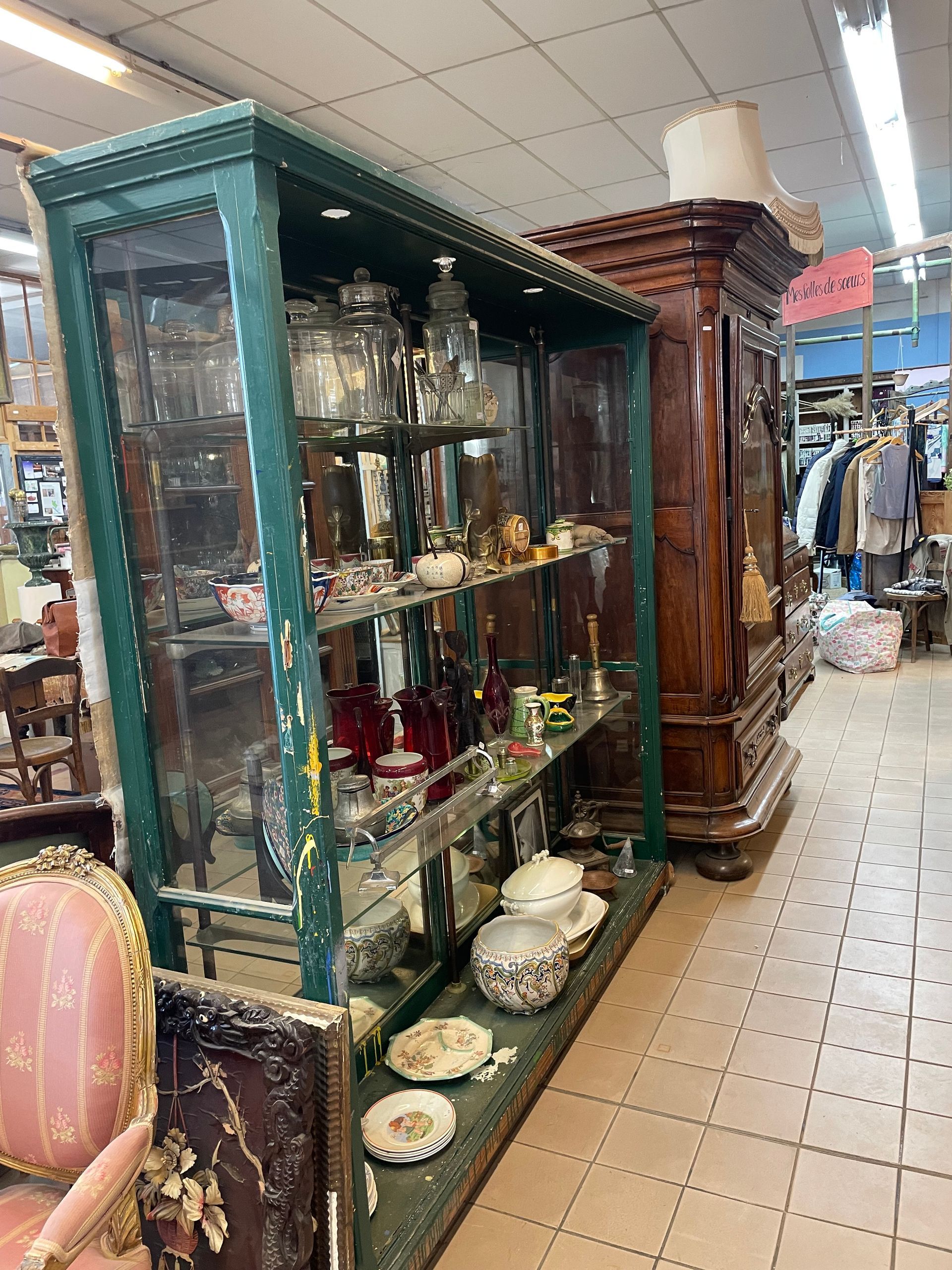 Etagère chez un antiquaire remplie de vaisselle ancienne