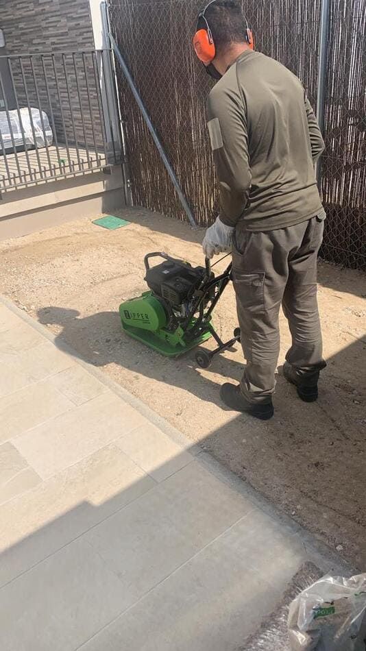Un hombre está usando una máquina en un patio.