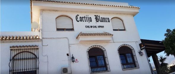 Edificio blanco con cartel de 