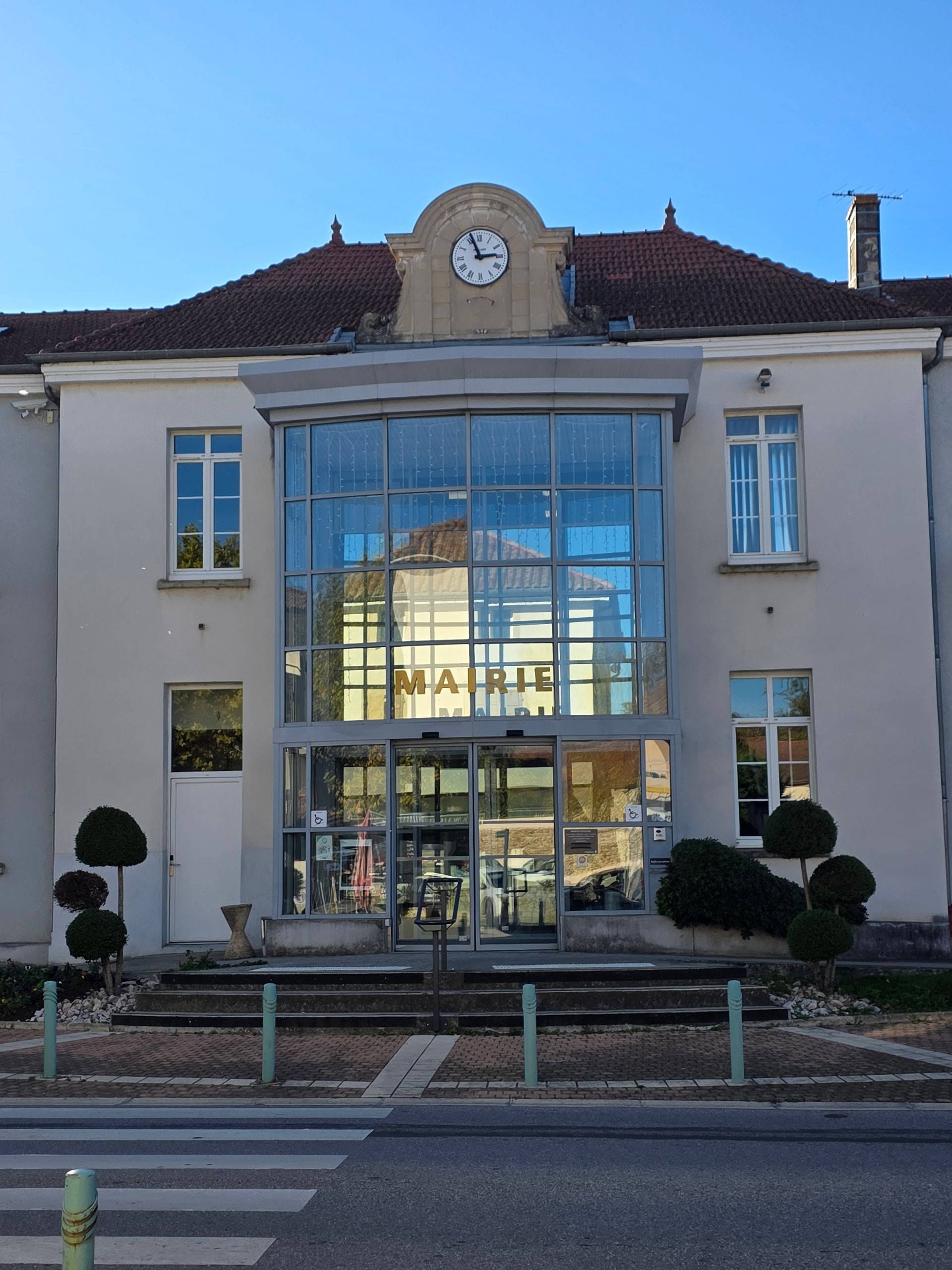 Hôtel de ville avec entrée vitrée, tour de l'horloge et enseigne « MAIRIE ».