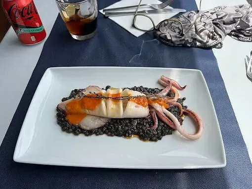 Un plato de comida en una mesa junto a una lata de Coca Cola.